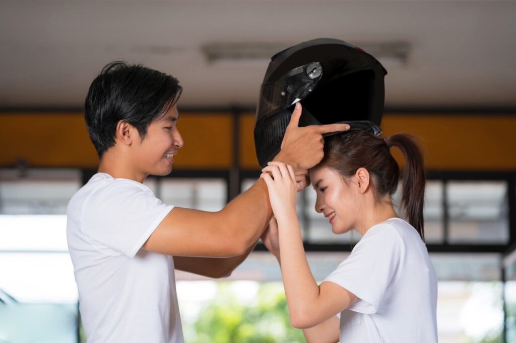 Image Of A Rider Giving Helmet To Its Pillion